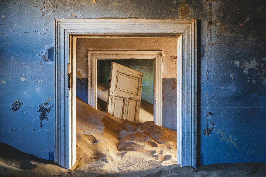 Abandoned building being taken over by encroaching sand in Kolmanskop, a ghost town near Luderitz in the Namib Desert, Namibia.